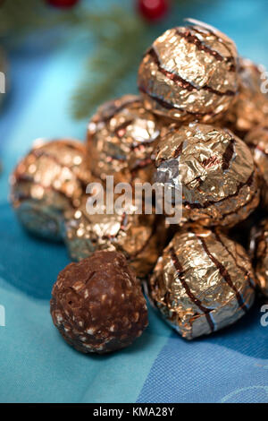 Pile of sweet round chocolate candies for christmas celebrations on a table cloth. Stock Photo