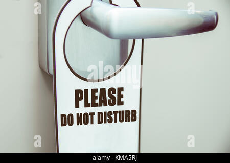 Door handle with door sign 'please do not disturb' in a hotel Stock Photo