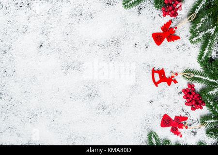 Christmas background with snowflakes, white snow, toys, candy, Christmas tree branches and New Year decor. Winter Holiday Frame Stock Photo