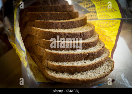 Sliced wholemeal brown bread on wooden chopping board Stock Photo