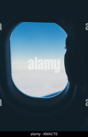 Woman looking out of plane window Stock Photo