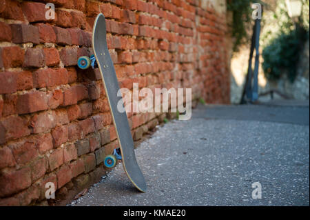 Skateboard leaning against wall Stock Photo