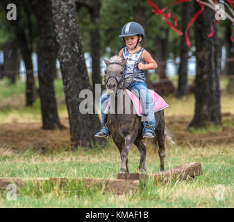 Four year old girl riding pony. Stock Photo