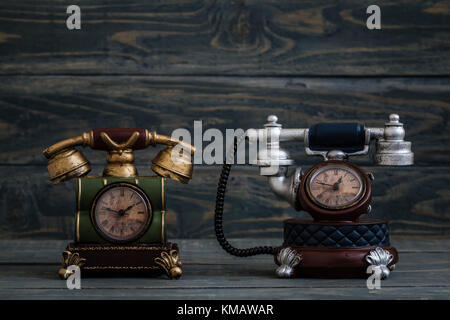 Desk clocks with antique telephone design on blue  background Stock Photo