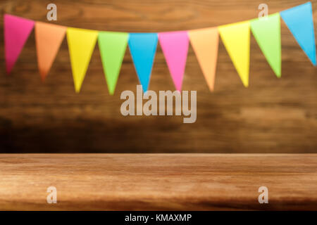 Wooden table in front of abstract blurred Christmas background flags. Place for text. The oak table. Stock Photo