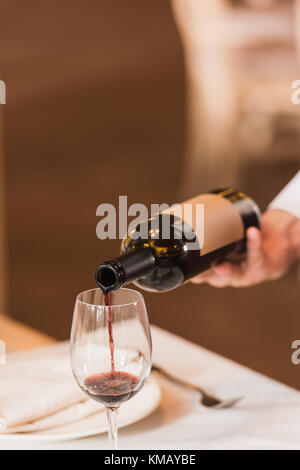 waiter pouring red wine Stock Photo