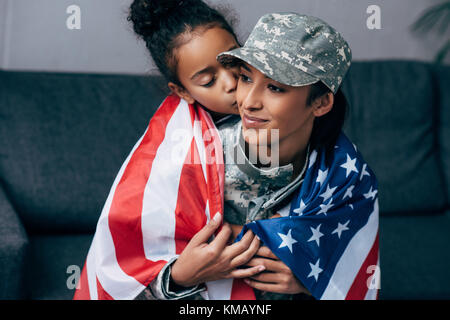 daughter kissing mother in military uniform  Stock Photo