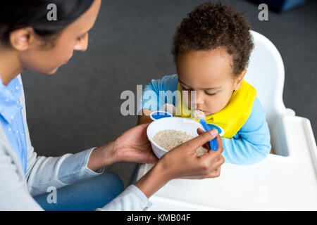 mother feeding son with porridge  Stock Photo
