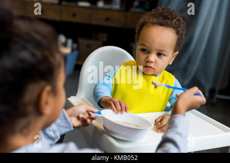 african american sister feeding brother Stock Photo