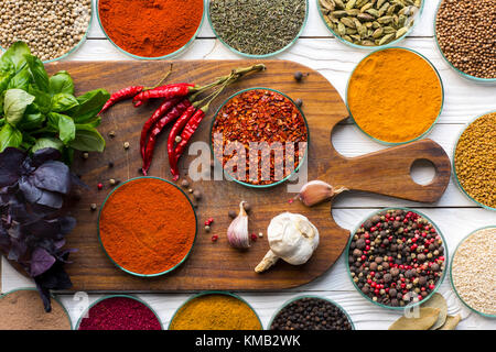 bowls with spices on wooden board and table Stock Photo