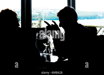 The silhouette of two customers in a restaurant; Stock Photo