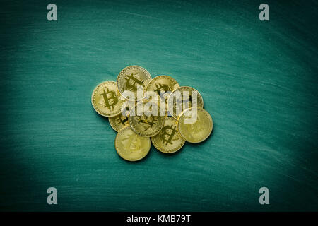 Golden bitcoins. Cryptocurrency. Coins of bitcoin on green chalkboard. Stock Photo