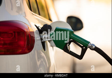 white car at gas station being filled with fuel Stock Photo