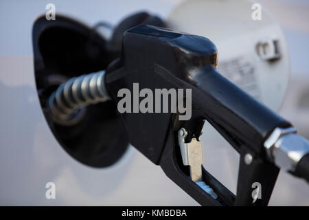 white car at gas station being filled with fuel Stock Photo