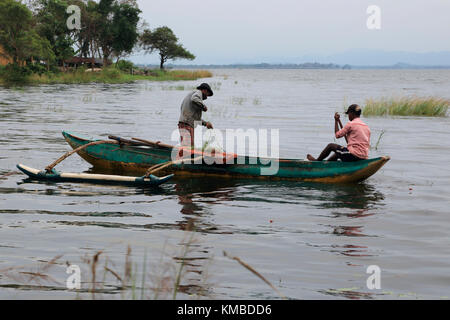 Men fishing from an outrigger canoe, in reservoir lake, Polonnaruwa, Central Province, Sri Lanka, Asia Stock Photo