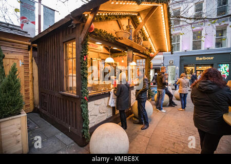 Shoppers And Revellers at the food market at Manchester Christmas Markets Around The City, Manchester, England, UK Stock Photo