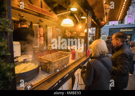 Shoppers And Revellers at the food market Manchester Christmas Markets Around The City, Manchester, England, UK Stock Photo