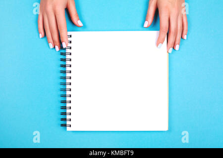 Two hands holding spiral notepad Stock Photo
