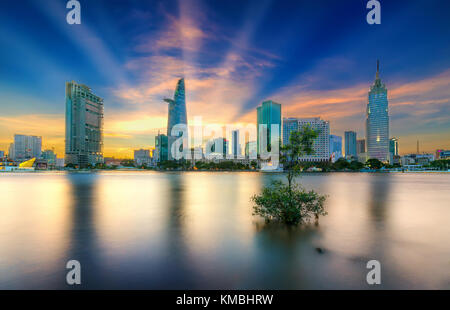 Riverside City sunrays clouds in the sky at end of day brighter coal sparkling skyscrapers along beautiful river Stock Photo