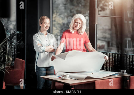 Young creative designer showing her work to a cheerful client Stock Photo