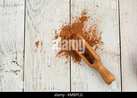 Cocoa powder on white rustic background, top view Stock Photo