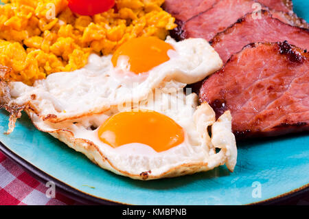 Strong breakfast with eggs and ham. Selective focus on the ham and eggs Stock Photo