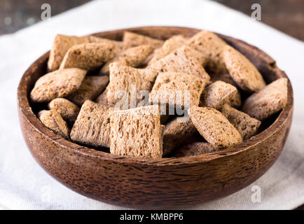 Sweet chocolate pillows in wooden bowl,selective focus Stock Photo