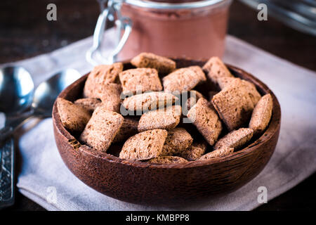 Sweet chocolate pillows in wooden bowl,selective focus Stock Photo