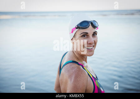 Portrait smiling mature female open water swimmer at ocean Stock Photo