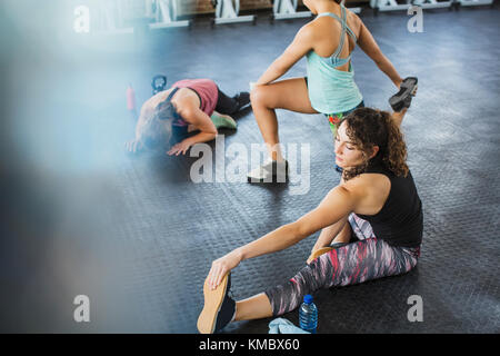 Young women stretching legs in gym Stock Photo