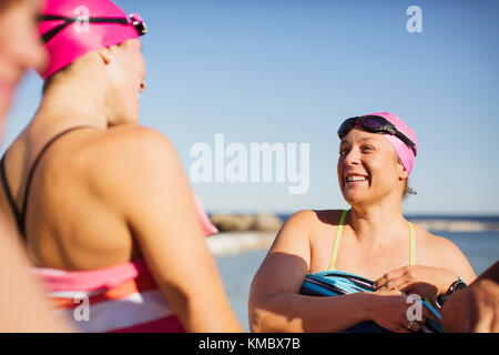 Smiling female open water swimmers drying off with towels Stock Photo