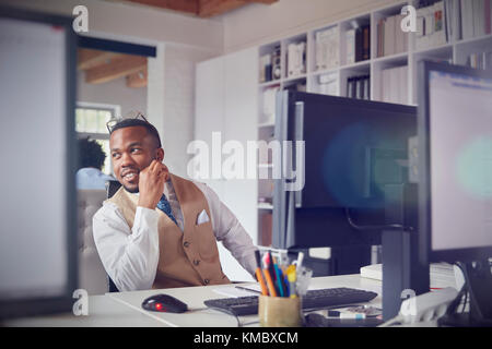 Smiling businessman working at computer in office Stock Photo