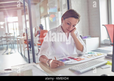 Female design professional reviewing color swatches in office Stock Photo