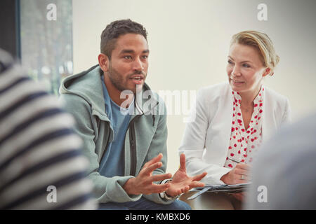 Young man talking in group therapy session Stock Photo