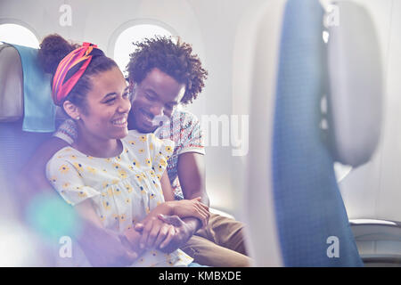 Affectionate young couple on airplane Stock Photo