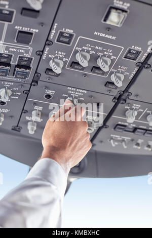 Pilot adjusting control instruments in airplane cockpit Stock Photo