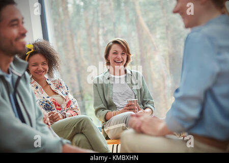 People smiling and laughing in group therapy session Stock Photo