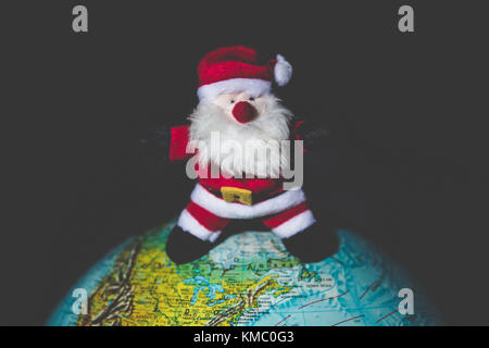 Santa Claus standing on a world globe. Stock Photo