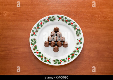Close up of a plate with christmas decorations and with chocolate cookies in tree shape. Stock Photo