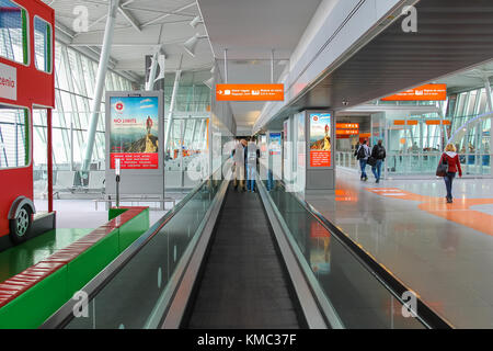 Warsaw, Poland - Apr 18, 2015: Passengers walking  through arrival area of Warsaw Chopin Airport. WAW is the largest and busiest airport in Poland. It Stock Photo