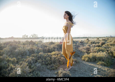 Young woman walking barefoot, alone in nature. Stock Photo