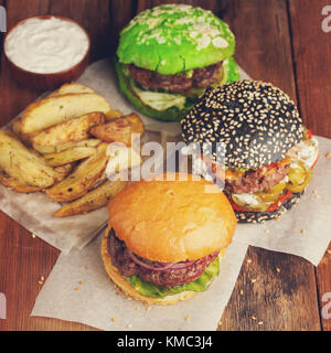 Closeup of set of three mini homemade Burger with marble beef and vegetables on a wooden Board. Stock Photo