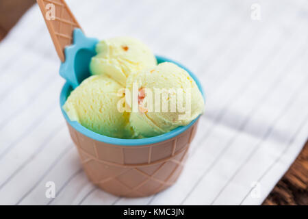 Vanilla ice cream with a taste of melon in a bowl on old wooden table. Stock Photo