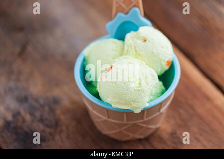Vanilla ice cream with a taste of melon in a bowl on old wooden table. Stock Photo