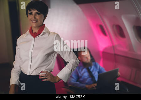 Air hostess standing with hand on hip Stock Photo