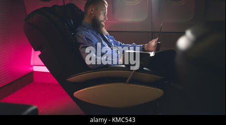 Businessman using laptop in airplane Stock Photo