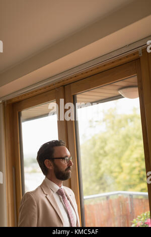 Man in full suit standing at home Stock Photo