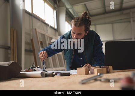 Carpenter drawing with compass on paper Stock Photo