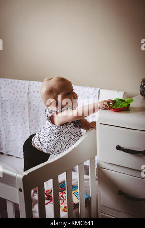 Cute girl trying to reach out the toy Stock Photo