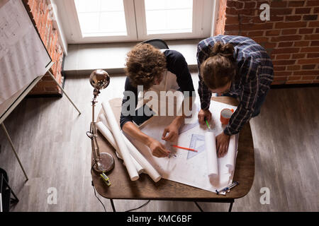 Male graphic designers working on blueprint Stock Photo